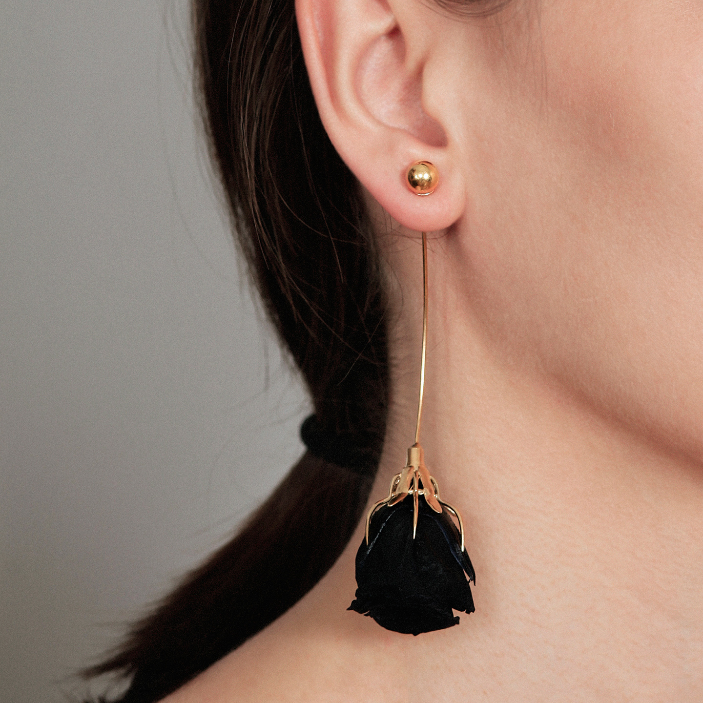 Long gold earring with natural black rose